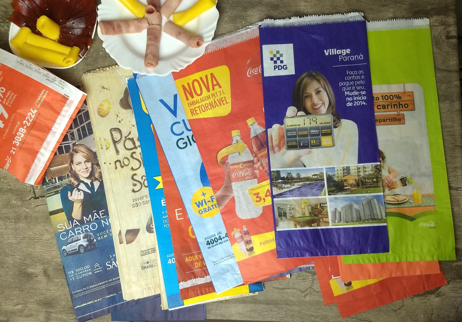 Diversos sacos de pão publicitários fotografados sobre uma mesa